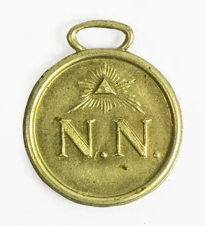 Amulett av nickel med initialerna N.N. och "Guds allseende öga", från Strängnäs