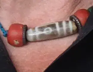 Dzi bead (center) with two Precious coral beads in necklace, from- 2016-09 Reinhold Messner (22) (cropped)