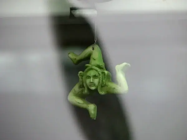 A green triskelion charm