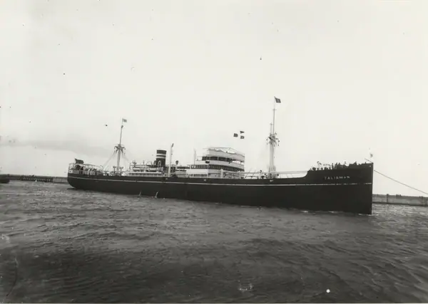 Foto i svartvitt visande lastmotorfartyget "TALISMAN" av Tönsberg under bogsering i Köpenhamn, 1930-talet.