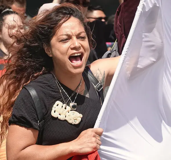 Māori woman holding protest banner Waitangi Day 2024 Wellington