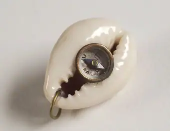 Compass encased within a shell, good luck charm