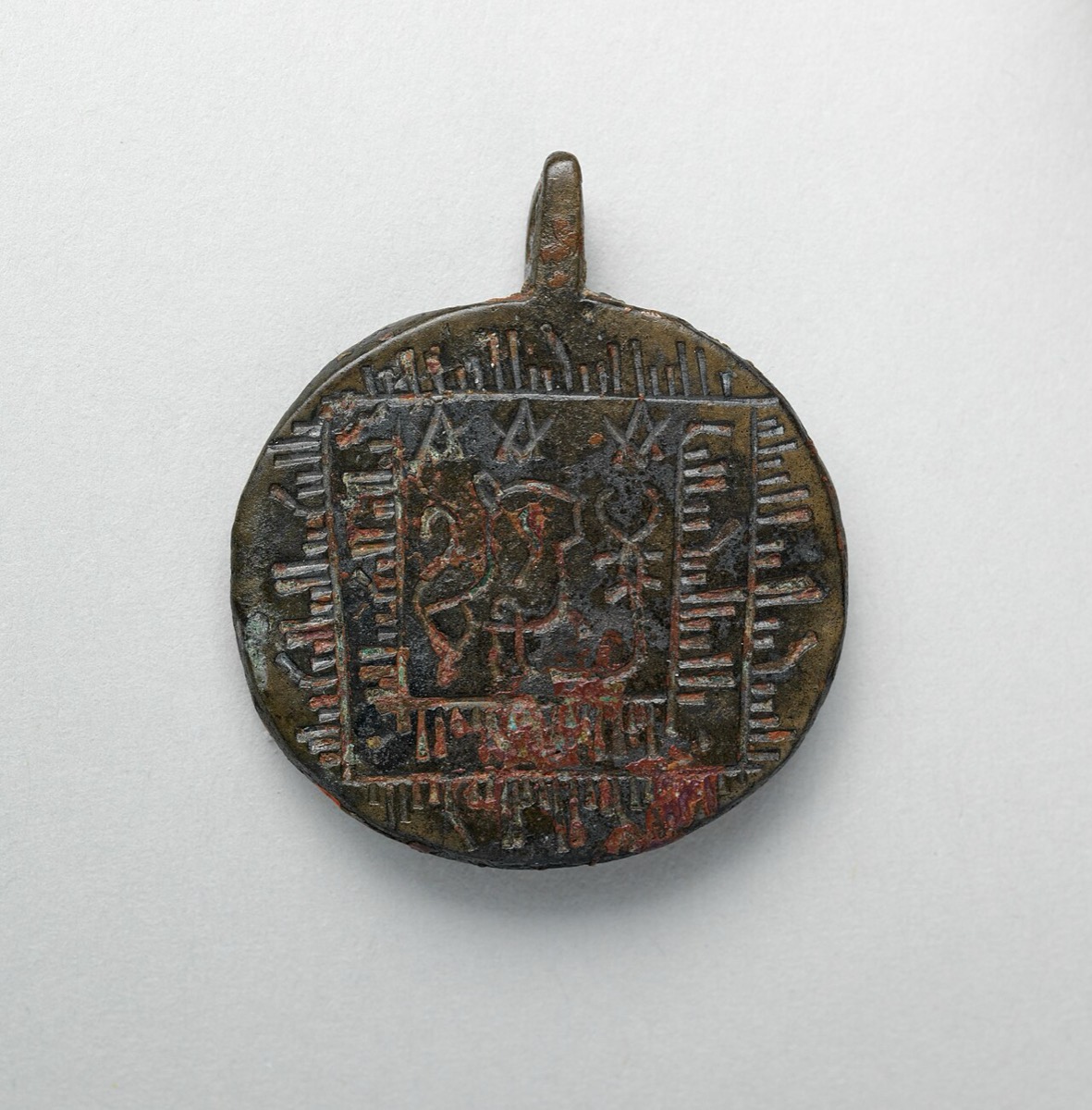 A pendant with lion, scorpion, and imitation script